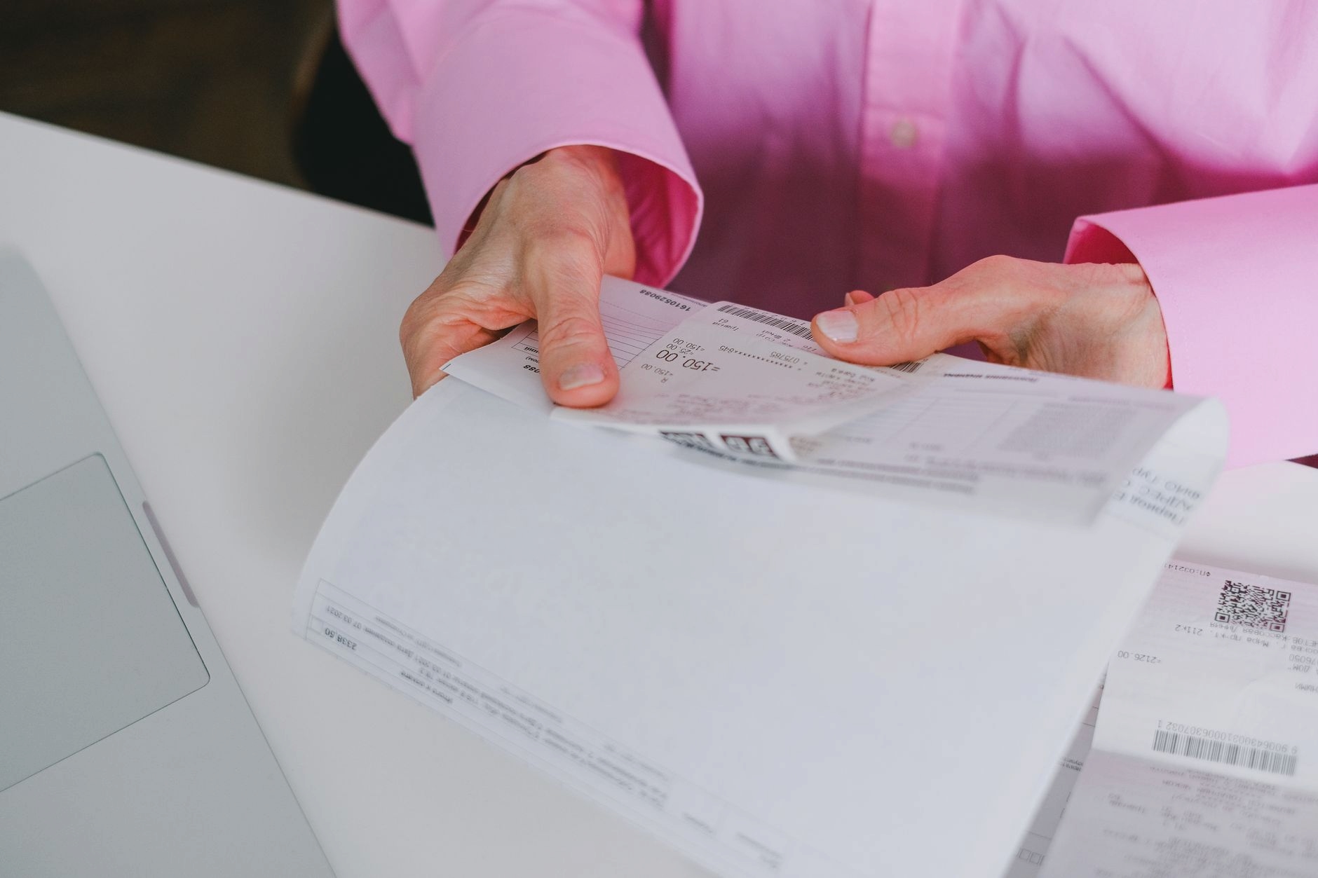 Freelancer reviewing invoice documents on a wooden desk